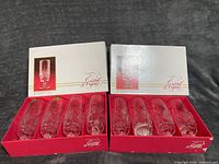 Two boxes each holding four cut crystal gold-rim beverage glasses