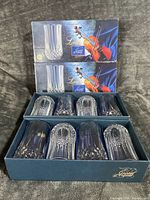 Two sealed Longchamp boxes and one opened box showing eight highball glasses in molded inserts