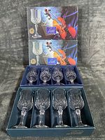 Two outer Longchamp boxes stacked above open inner tray showing eight crystal goblets