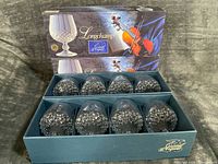 Blue Longchamp presentation box opened to show two tiers holding eight diamond-cut crystal snifters