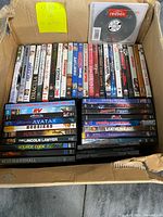 Open box showing entire assortment of DVD cases stacked with one loose CD on top