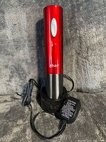 Wine opener docked in charging base with AC adapter