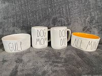 Group shot of both mugs and both bowls showing text and colors