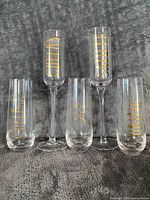 Five glasses upright showing types and gold lettering