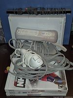 Console, controllers, sensor bar, and three game cases stacked