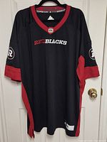 Full front view of the Ottawa RedBlacks jersey hanging