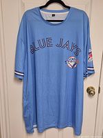 Front view of light blue Blue Jays shirt showing script logo and front emblem