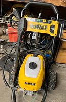 Front view showing DeWalt pressure washer, hose, wand, wheels, detergent tank