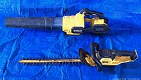 Top view of DeWalt blower and hedge trimmer with battery attached