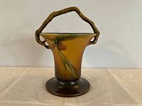 Front view of Roseville Pinecone basket vase showing pinecone motif and handle