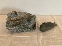 Both Inuit stone carvings side by side showing relative sizes