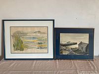 Both framed paintings side by side on table