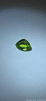 Trillion cut vivid green peridot top view