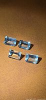 Four rectangular aquamarine stones on surface