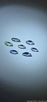 Seven marquise cut multicolor tanzanite gemstones on light background