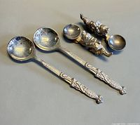 Two ladles and two dragon rests displayed on surface