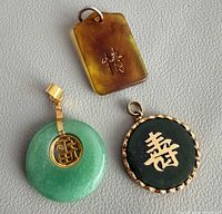 Front view of all three pendants showing overall design and Chinese characters