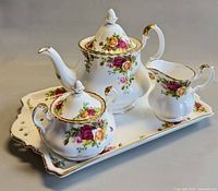 Teapot, sugar bowl, creamer on tray showing complete set