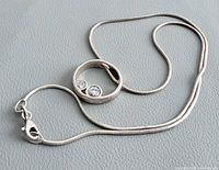 Full view of sterling silver necklace showing snake chain, pendant, and clasp