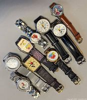 Group shot of all eleven Mickey Mouse themed wristwatches showing variety of cases and straps