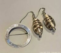 Front view of brooch and earrings showing design and texture