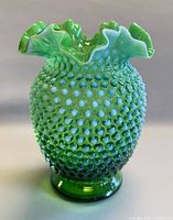 Full front view of green opalescent hobnail vase
