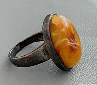 Oblique view of ring showing amber cabochon in silver setting