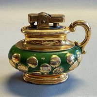 Front view of Aurora desktop lighter showing green ceramic body, gold raised dots and lighter mechanism