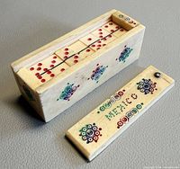 Domino box opened with tiles inside showing off-white material and red pips