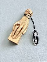 Top view showing gold tone hand, faux pearl ring, Florenza tag