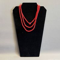 Necklace doubled on black display bust showing color and bead uniformity