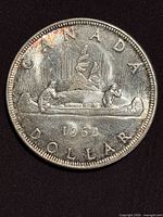 Reverse of 1962 Canadian silver dollar showing Voyageur canoe design and date