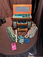 overall view of jewelry box, necklaces, watch, brooch