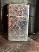 Front of silver-tone lighter showing crosshatch pattern