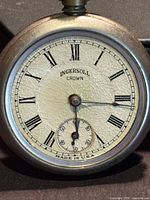 Front view of Ingersoll Crown pocket watch showing dial details and missing crystal