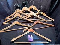 Group shot of all nine vintage advertising wooden hangers