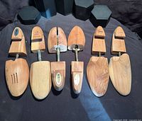 Eight cedar shoe tree pieces arranged showing toe and heel sections, partial branding visible