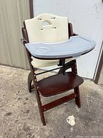 Full view of Abiie wooden high chair with tray attached