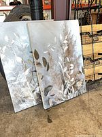 Pair of botanical canvas prints leaning against post