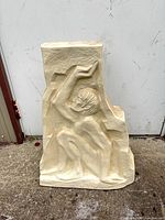 Front view of cream relief statue showing kneeling figure