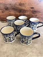 Six blue & white hand-painted ceramic mugs grouped