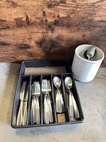 flatware set in organizer next to utensil crock