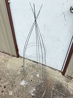Single galvanized metal tomato cage standing upright
