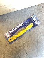 Front view of packaged Screen Tight Rollerknife showing yellow handle and wheels
