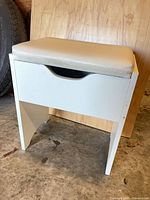 Front view of white stool with padded vinyl seat closed