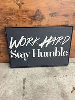 Front view of black canvas sign with white text