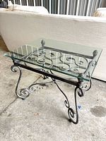 table angled view showing wrought iron base and glass top