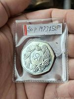 Reverse showing interlocking hands design and 1973 date inside protective sleeve