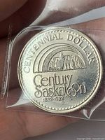 Obverse showing skyline and "Centennial Dollar" legend