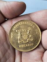 Obverse of medallion showing Ontario coat of arms and dates